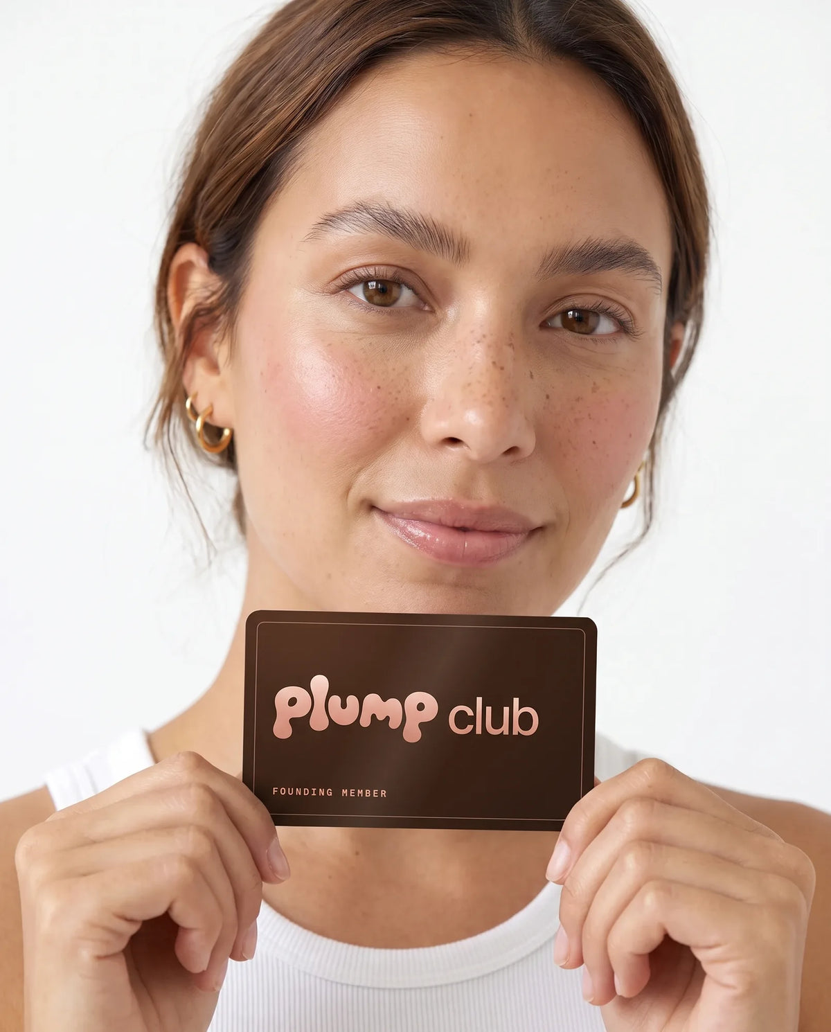 A woman holding up her plump club member card